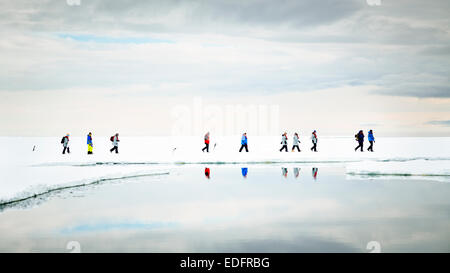 Passeggeri dal Akademik Shokalskiy una passeggiata sul ghiaccio con Adelie pinguini. Foto Stock