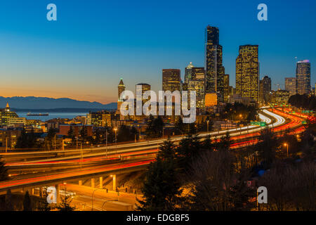 Il traffico di Freeway e skyline del centro al tramonto, Seattle, Washington, Stati Uniti d'America Foto Stock