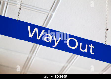 Blue Way Out segno appeso su una catena di metallo dal soffitto di un British National Health Service NHS hospital Foto Stock