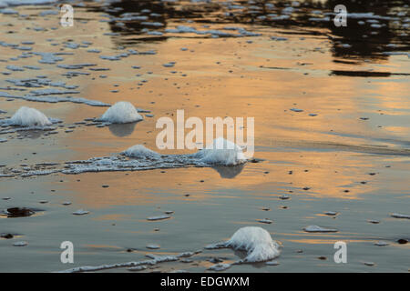 Swanage spiaggia al tramonto con il surf e la riflessione della luce Foto Stock