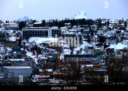 Una neve montagna ha raggiunto il picco di poke fino oltre il Tromsø cityscape, Norvegia. Foto Stock