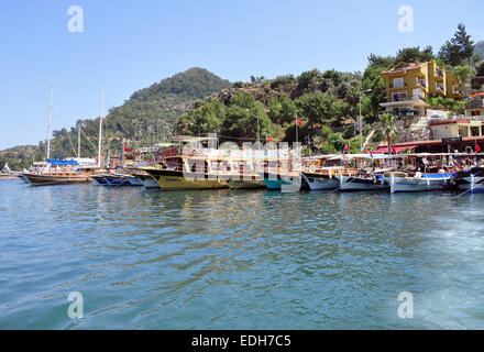 In legno barche turistiche da Marmaris linea fino al porto a Turunc mentre i turisti di visitare il mercato locale. Foto Stock