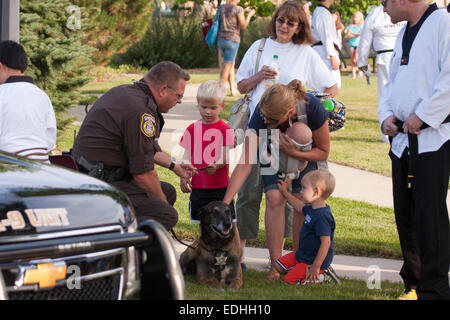 La Contea di Waukesha K-9 unità Sheriff parlando a una famiglia con la sua K-9 cane Foto Stock