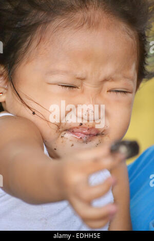 Un ritratto di bella asiatica bambina facendo un gesto nel suo volto, non vogliono più cioccolatini Foto Stock