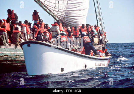 Gli immigrati haitiani scramble a scendere una zattera di fortuna in un U.S. La guardia costiera della scialuppa di salvataggio dopo essere stato interdetto in mare sul loro modo di Florida 10 novembre 1991 nel mar dei Caraibi. I rifugiati verranno portati nei campi di Guantanamo Bay a Cuba per il rimpatrio. Foto Stock