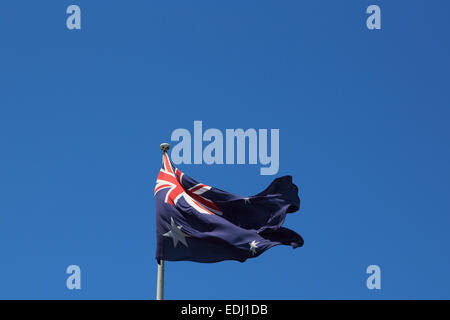 La fotografia di una bandiera australiana al vento contro uno sfondo di cielo blu. Foto Stock