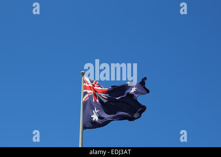 La fotografia di una bandiera australiana al vento contro uno sfondo di cielo blu. Foto Stock