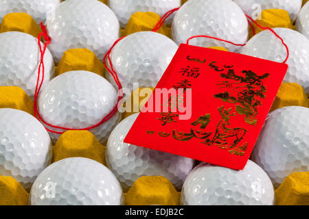 Tipica la Cina busta rossa e palline da golf nella casella gialla Foto Stock