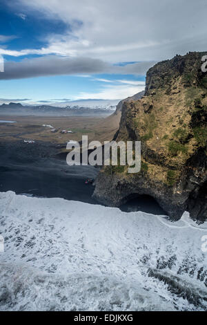 Vista aerea di scogliere e onde, spiaggia di sabbia nera, Dyrholaey, Islanda Foto Stock