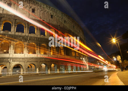 Colosseo di notte con luci auto, Roma, Italia Foto Stock