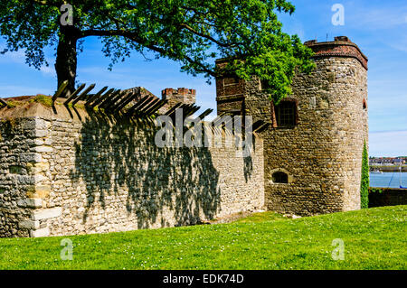 La pietra south tower e pareti con incorporato lungo sharp picchi di acciaio parzialmente mascherata da ombra sulla banca del fiume Medway Foto Stock