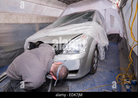 Un dipendente AutoRestore preparando a spruzzo per spruzzare un auto all'interno del portatile tenda a spruzzo ha portato con sé nel Regno Unito Foto Stock