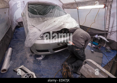 Un dipendente AutoRestore preparando a spruzzo per spruzzare un auto all'interno del portatile tenda a spruzzo ha portato con sé nel Regno Unito Foto Stock