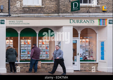 Le persone che cercano nella finestra di Durrants agente immobiliare a Southwold , Suffolk , Inghilterra , Inghilterra , Regno Unito Foto Stock