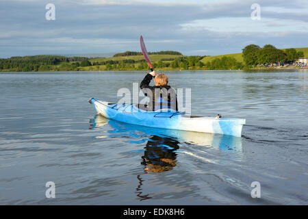 Giovane ragazzo in un kayak su Killington L:ake, Cumbria, Regno Unito Foto Stock