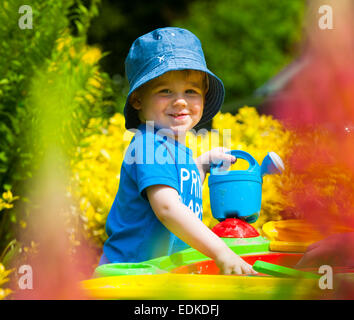 Un bambino di due anni la riproduzione in una buca di sabbia. Foto Stock