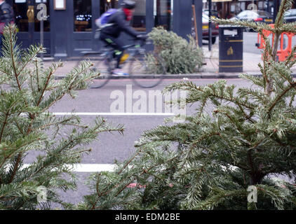 Alberi di Natale oggetto di dumping nelle strade di Londra dopo la dodicesima notte Foto Stock