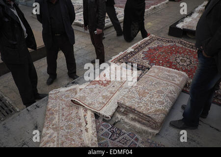 Tehran, Iran. Il 7 gennaio, 2015. 7 gennaio 2015 - Teheran, Iran - Gli uomini stanno intorno persiano tessuti a mano tappeti in Tehran moquette del Bazaar. Morteza Nikoubazl/ZUMAPRESS © Morteza Nikoubazl/ZUMA filo/Alamy Live News Foto Stock