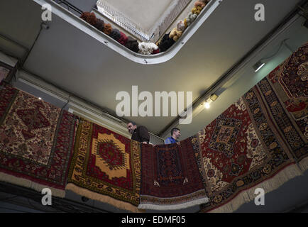 Tehran, Iran. Il 7 gennaio, 2015. 7 gennaio 2015 - Teheran, Iran - uomini iraniani stare accanto a persiano tessuti a mano tappeti impiccato da un balcone in Tehran moquette del Bazaar. Morteza Nikoubazl/ZUMAPRESS © Morteza Nikoubazl/ZUMA filo/Alamy Live News Foto Stock