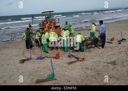 Bidello per ripulire il cestino in Kuta Beach, Bali Indonesia. Kuta è una delle spiagge più famose del mondo. Foto Stock