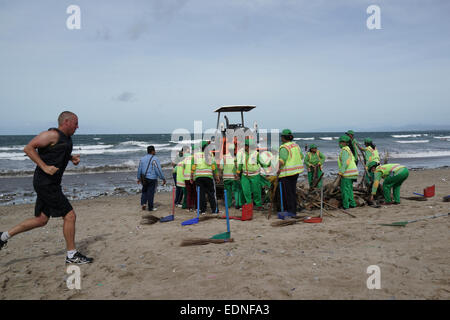 Bidello per ripulire il cestino in Kuta Beach, Bali Indonesia. Kuta è una delle spiagge più famose del mondo. Foto Stock