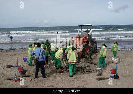 Bidello per ripulire il cestino in Kuta Beach, Bali Indonesia. Kuta è una delle spiagge più famose del mondo. Foto Stock