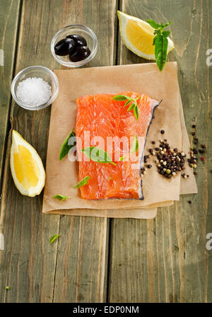Salmone su una tavola di legno con limone e erbe aromatiche . Foto Stock