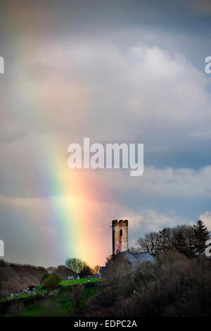 Rainbow oltre la chiesa di St James in Manorbier South Wales UK Foto Stock