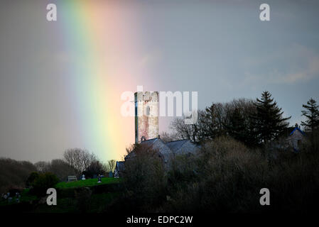 Rainbow oltre la chiesa di St James in Manorbier South Wales UK Foto Stock