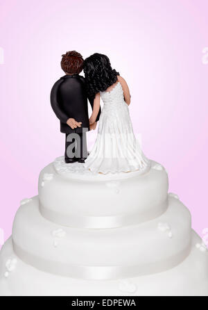 Un cake topper che mostra lo sposo incrocio le dita Foto Stock