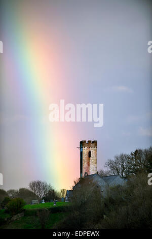 Rainbow oltre la chiesa di St James in Manorbier South Wales UK Foto Stock