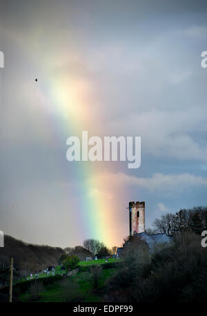 Rainbow oltre la chiesa di St James in Manorbier South Wales UK Foto Stock