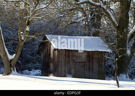 Paesaggio con capanna di legno nella neve Foto Stock