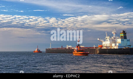 Nave cisterna con la scorta rimorchiatori lasciando port. Foto Stock