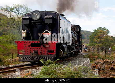 Curiosi di guardare un treno a vapore sul Welsh Highland Railway attraversare il fiume Glaslyn vicino Beddgelert in Snowdonia, Wales, Regno Unito Foto Stock