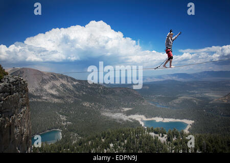 Highliner maschio nel cappello da cowboy passeggiate a piedi 125 highline su un lago in un gap sulla parte superiore della cresta Mammut Foto Stock