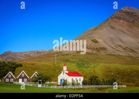 Piccolo villaggio in Islanda con chiesa e case del fondo erboso Foto Stock