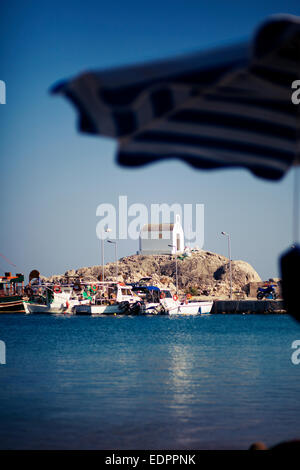 Kolymbia beach bay. Vista sulla piccola chiesa bianca dalla riva. Rhodes, Grecia Foto Stock