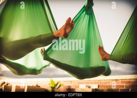 Un gruppo di donne eseguire aerial yoga. Foto Stock