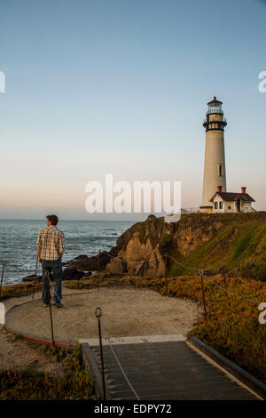 Un uomo gode di vedute del tramonto a Pigeon Point Lighthouse vicino a Pescadero, California in una giornata di sole. Foto Stock