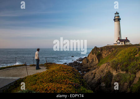 Un uomo gode di vedute del tramonto a Pigeon Point Lighthouse vicino a Pescadero, California in una giornata di sole. Foto Stock