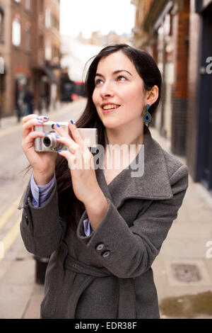 Giovane donna in possesso di una telecamera Foto Stock