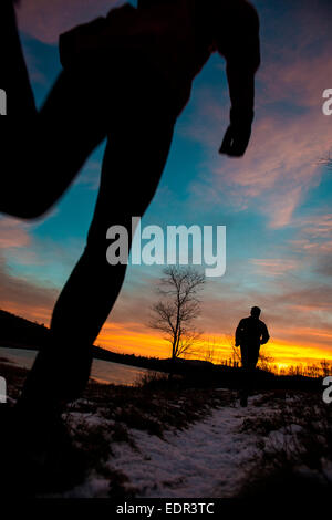 La mattina presto trail running nell'alba di una fredda mattina autunnale. Foto Stock