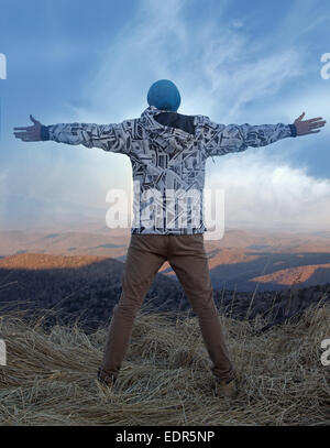 Libertà in montagna uomo stand con ampiamente distanziate le nuvole di armi Foto Stock