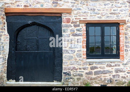 Tipica tradizionale cottage di legno porta e finestra a battente su un vecchio edificio in pietra a Porlock nel Somerset, Regno Unito Foto Stock