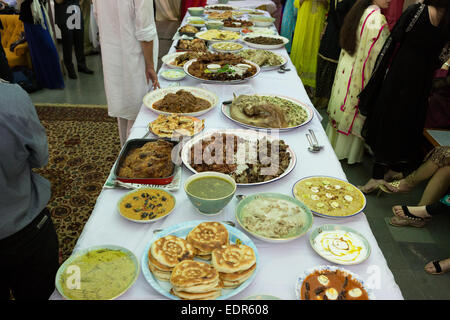 Un assortimento di piatti Hyderabadi posti su un lungo tavolo Foto Stock