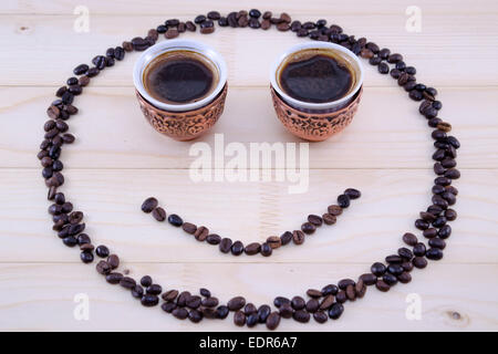 Smiley fatto di chicchi di caffè e vintage due tazze di caffè come occhi Foto Stock