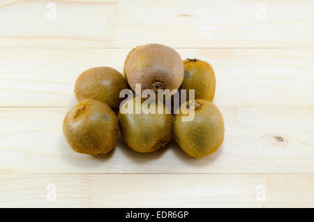 Un mazzetto di intonso kiwi su un tavolo di legno Foto Stock