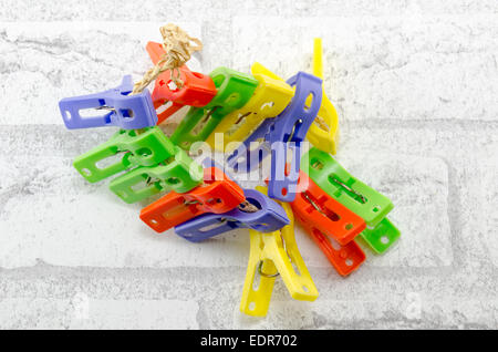 Mazzetto di coloratissimi clothespins isolato sul muro bianco Foto Stock
