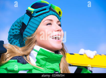 Closeup ritratto di carino felice sciatore ragazza del cielo blu, sfondo extreme sport invernale, uno stile di vita attivo concept Foto Stock